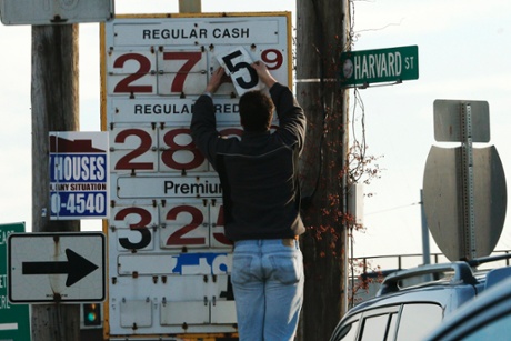 A man changes the price for a gallon of gasoline at a gas station in Medford, Massachusetts December 4, 2014.
