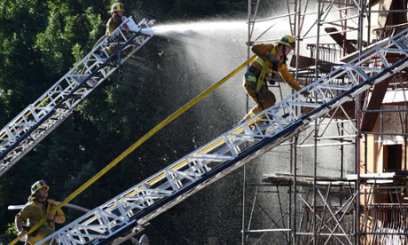 Firefighters douse the remains of the fire.