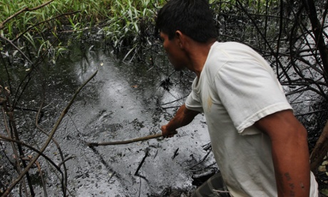 A Kukama Indian check oil following oil spill due to broken pipeline in Amazonian forest of Peru that polluted the Marañón River, a major tributary of the Amazon, June 2014.