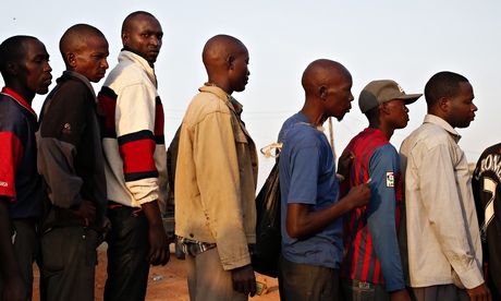 Bus passengers wait to be searched for weapons by Kenyan police in the town of Mandera