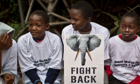 Young demonstrators sit with a placard as they prepare to take part in the 