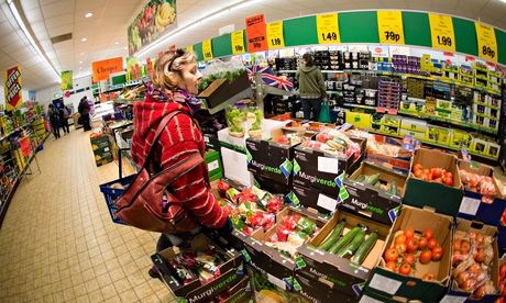 A middle aged woman shopping for fresh vegetables and other food in LIDL discount supermarket, UK