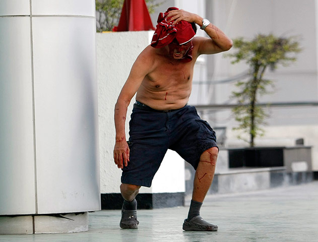 Bangkok Gunfight: A injured protester flees from the gun battle in Bangkok