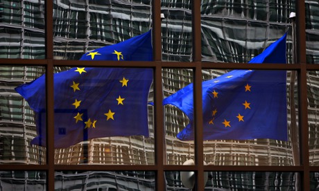 A European flag reflects in a building of the EU headquarters in Brussels.