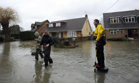 A fireman speaks to residents wading through floodwaters as flooding continues in Wraysbury, west of London on 11 February, 2014.