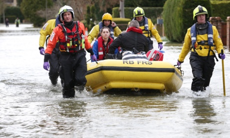 Members of Royal Berkshire Fire & Rescue squad evacuate a family from flooded Wraysbury.