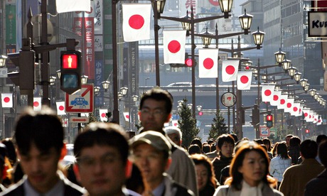 People walk under Japanese national flag