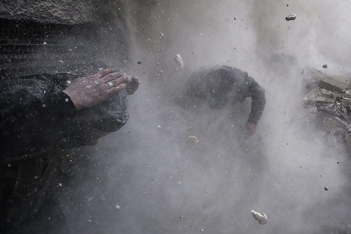 20 Photos: rebel fighters take cover from flying debris in Damascus