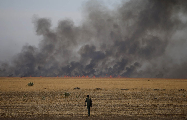 20 Photos: A rebel fighter walks in front of a bushfire in Upper Nile State