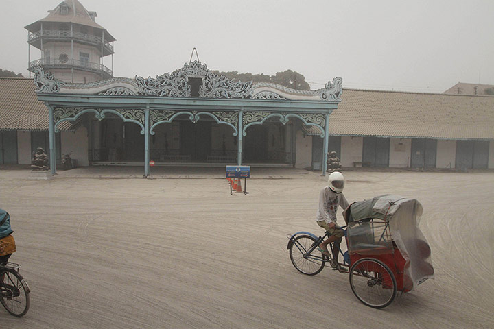 20 Photos: A becak driver pedals on the ash covered ground of the Sultan's palace