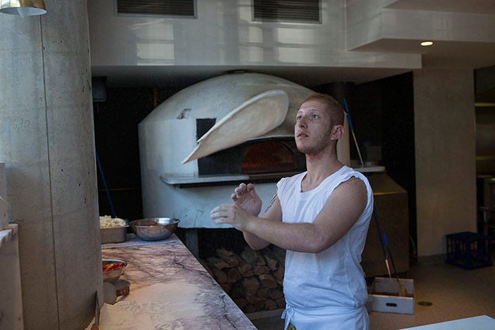 AUSTRALIA ONLINE: Man with no sleeves making a pizza base