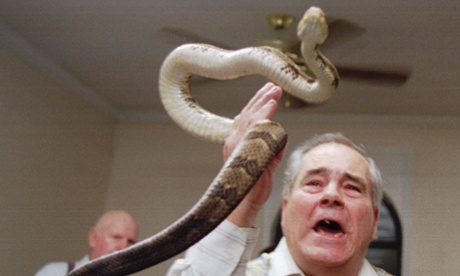 Junior McCormick handling a rattlesnake as Homer Browing looks on during services at the Church of the Lord Jesus in Kingston, Georgia, in 1995.