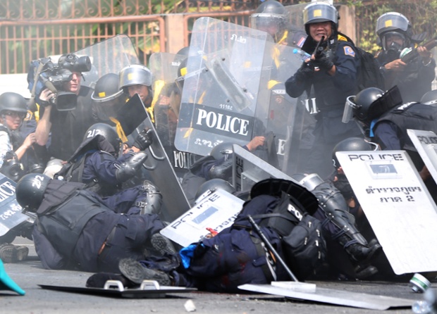 Riot police officers fall after a bomb blast during a clash.