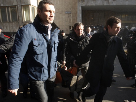 The Head of Udar or Punch party Vitali Klitschko  together with other anti-government protesters carry a wounded man during clashes with riot police in Kiev on Tuesday.