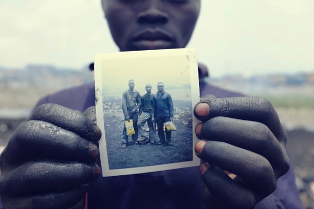 Pieter Adongo, 17, holds a Polaroid of himself and his friends, Desmond Atanga, 17, and Sampson Kwabena, 16