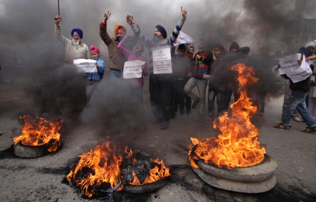 Sikhs shout slogans and burn tyres during a protest against Congress party leader Rahul Gandhi in Jammu, India, after he refused to apologise for the riots that killed more than 3,000 Sikhs saying he was not in operation in the Congress party in 1984.