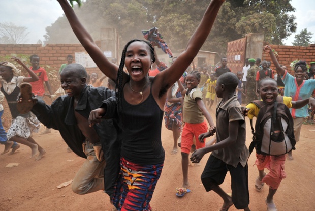 People cheer as they run behind the car transporting transitional President Catherine Samba-Panza after her visit to a camp for displaced civilians in Bangui,  Central African Republic.