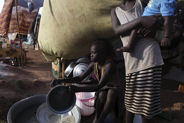 20 Photos: A girl displaced by fighting in South Sudan washes dishes in a camp in Juba