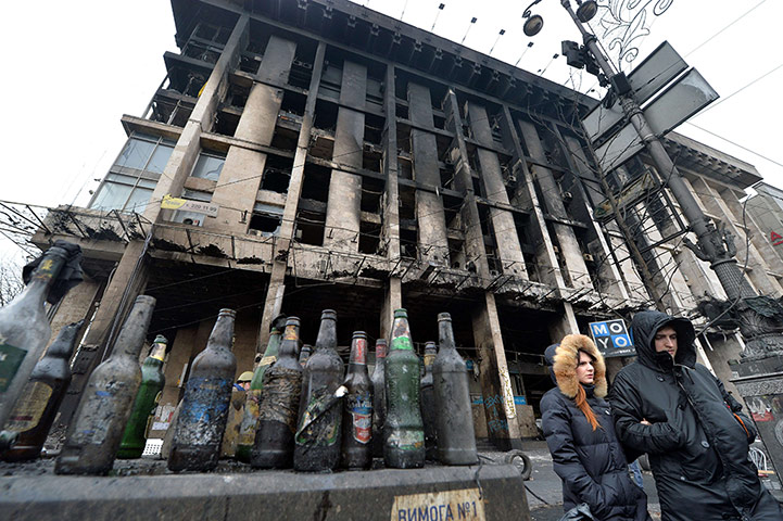 kiev protests: A couple walks past empty Molotov cocktails