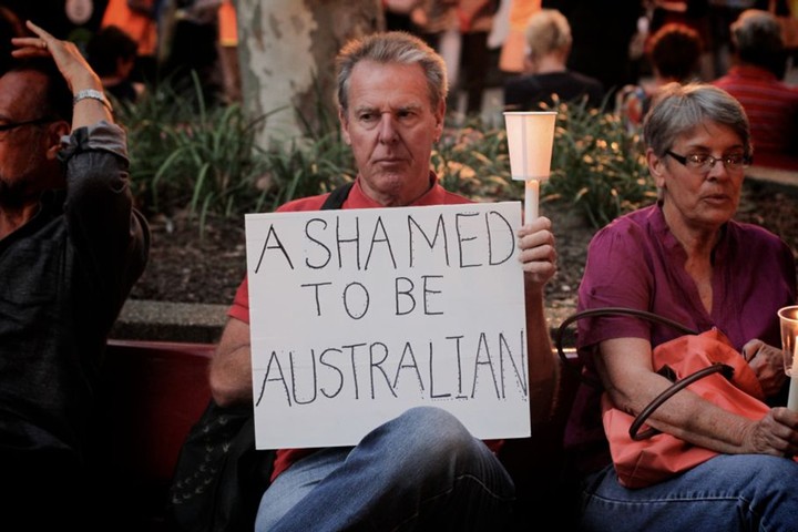 Light The Dark: A man holds a placard in Sydney