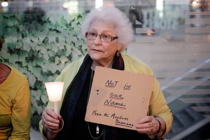 Light The Dark: A woman at vigil in Sydney holds a placard