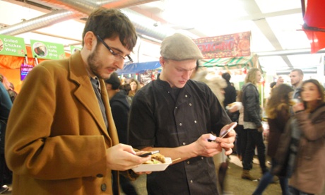 Alex Hern (l) et Olivier Rynkiewicz (r) faire un paiement en dogecoin pour un hamburger.