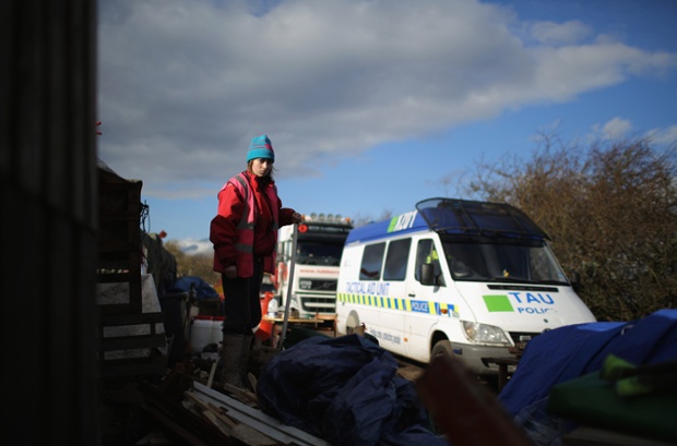 An anti-fracking campaigner looks on as police escort trucks leaving the Igas Barton Moss exploration facility in Barton, England.