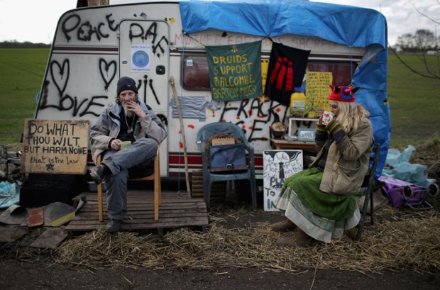 Anti-fracking campaigners and druids Lardon and Guinevere sit outside their donated caravan near the Igas Barton Moss exploration facility in Barton, England.