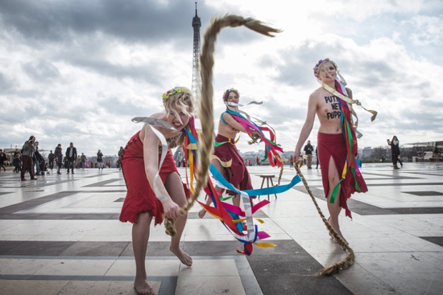 Members of protest group Femen whip with plaits resembling the hairstytle of Ukrainian politician Yulia Tymoshenko, on the Human Rights Square, near Eiffel Tower in Paris, France.