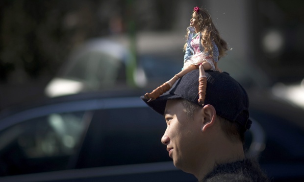 Tommy Ton seen carry a barbie doll on the head outside the Giorgio Armani show in Milan, Italy.