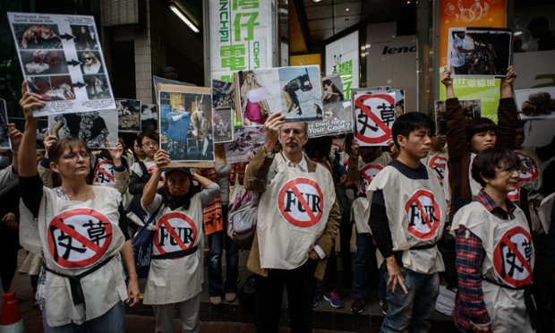 Demonstrators display placards as they protest against fur products on the opening day of the Hong Kong International Fur & Fashion Fair.