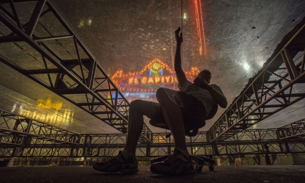 Rick Gamboa patches small holes in a plastic roof that will protecting Oscar's red carpet from the rain during the preparations for the upcoming 86th Academy Awards in front of the Dolby Theatre in Hollywood, California.