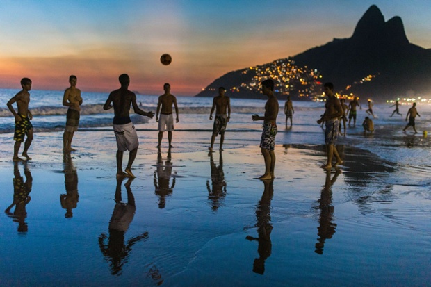 Men play football at Ipanema beach in Rio de Janeiro, Brazil.
