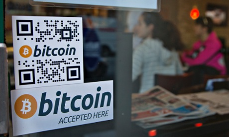 Signs on a window advertise a bitcoin ATM machine that has been installed in a cofee shop.