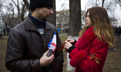 A pro-Russia woman ties a Crimean Ribbon on her friend's arm in Sevastopol, Crimea, Ukraine