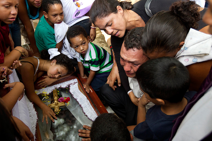 Caracas : Relatives of a gunshot victim cry over his coffin during his funeral ceremo