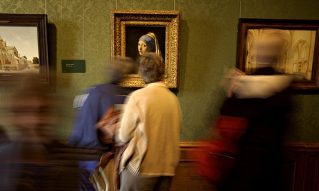 People pass Johannes Vermeer's The Girl With the Pearl Earring in Mauritshuis museum
