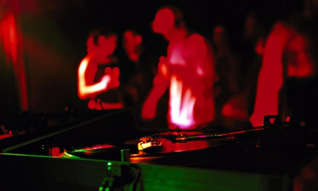 Record on decks with people dancing in background