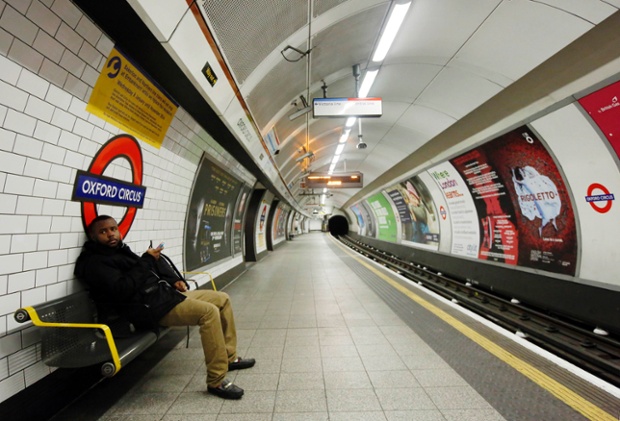 A passenger waits for a tube that did not arrive on an empty platform during rush hour at Oxford Circus.