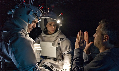 Alfonso Cuarón directs Geroge Clooney and Sandra Bullock on the set of Gravity.