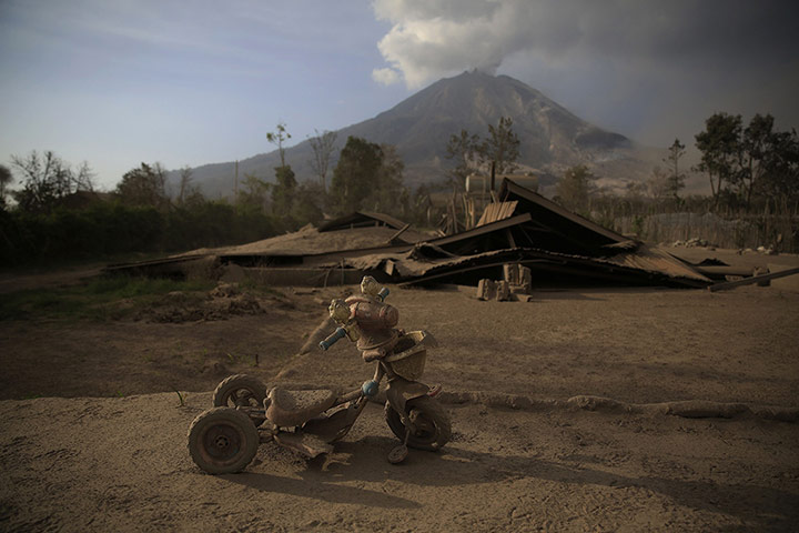 20 Photos: A child's tricycle is covered with ash from the Mount Sinabung eruption
