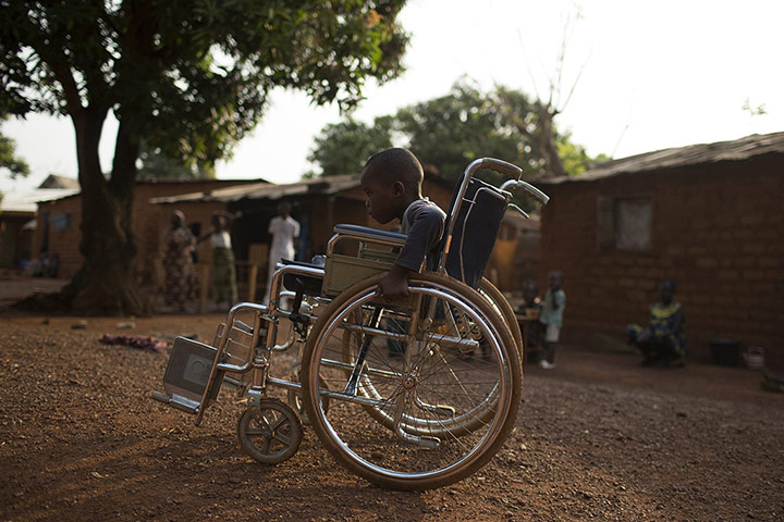 20 Photos: Mougounou pushes his wheel chair close to his home in Bangui