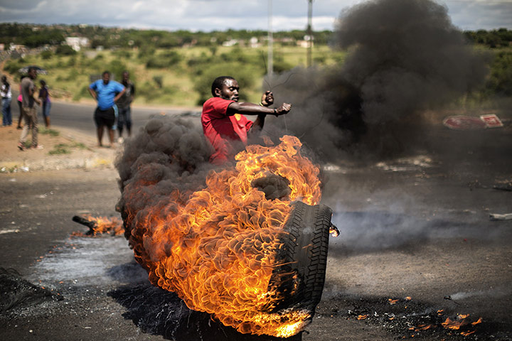 20 Photos: A demonstrator swings a burning tyre near Pretoria during a protest