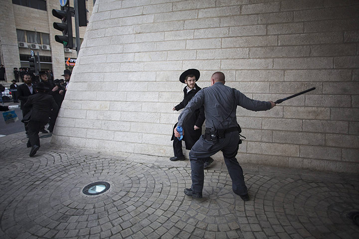 20 Photos: A policeman uses a baton at an ultra-Orthodox Jewish protester in Jerusalem