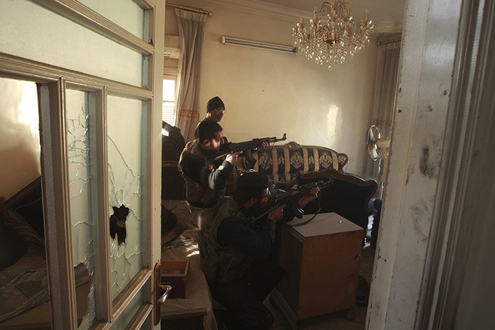 20 Photos: FSA fighters aim their weapons inside a house in Aleppo