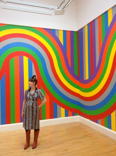 Your Pictures Clash: Woman standing beside bright stripy wall