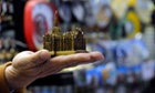 A vendor holds up a statuette of Milan's Duomo gothic cathedral.