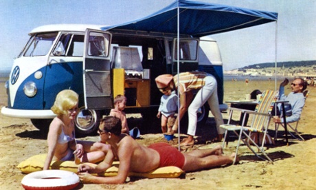 A family soak up the sun with their Volkswagen camper van, while on holiday in Devon in the 60s.