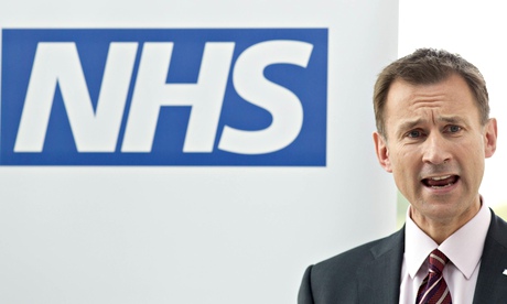 Jeremy Hunt speaking in front of big NHS logo