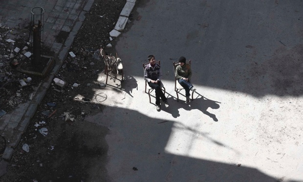 Damascus, Syria: Children sit near debris along a street in Duma neighbourhood.